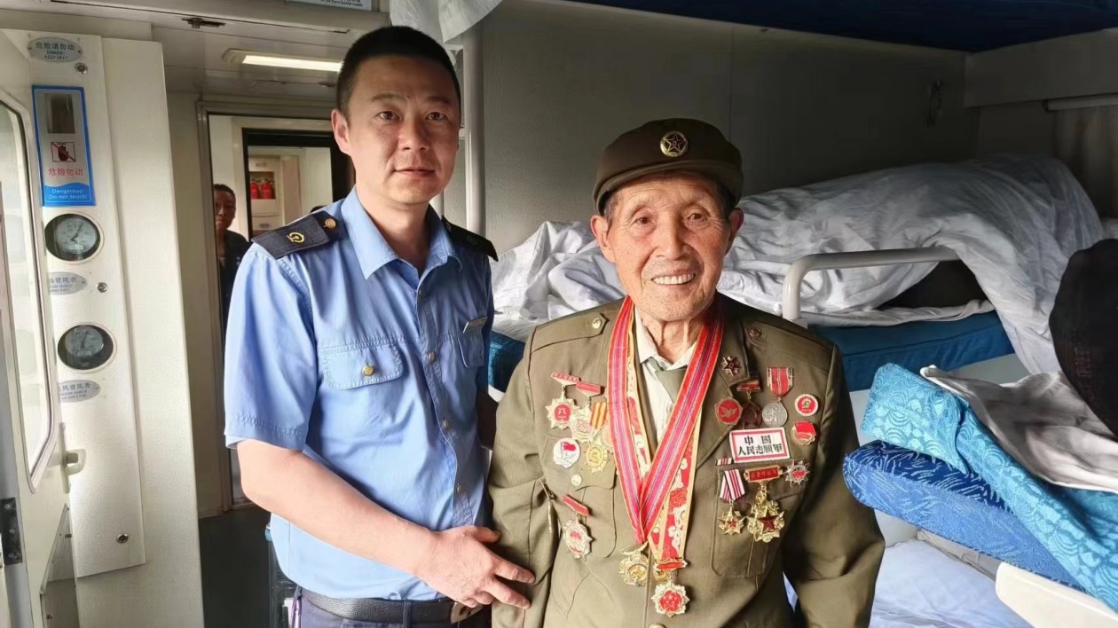 老英在k666次列車上為旅客講戰鬥故事