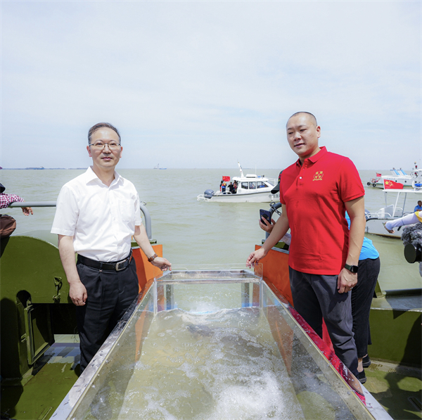 圖二蘇州市僑聯主席李文輝（左）和上海交通大學醫學院蘇州九龍醫院董事長孫曦（右），將1尾長達1.3米的「水中國寶」中華鱘放歸長江.jpg