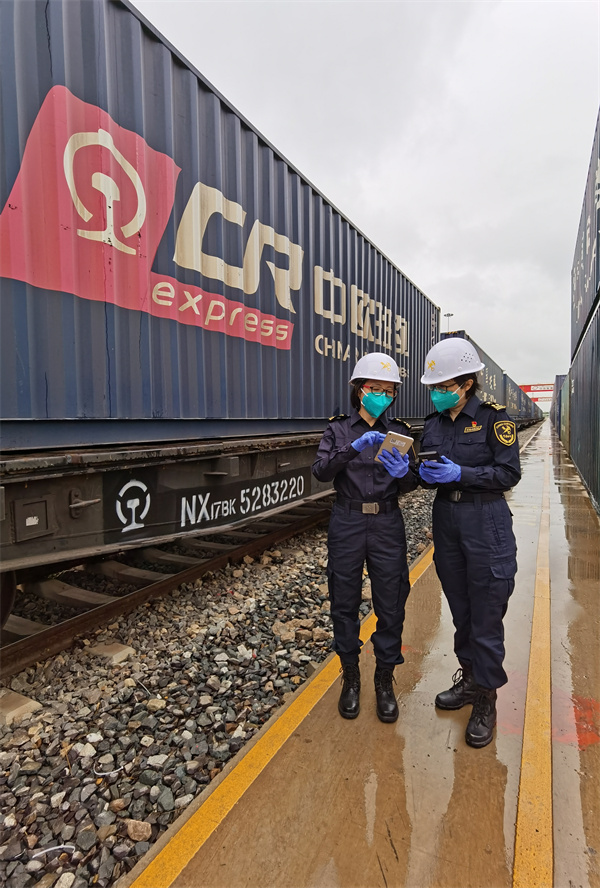 圖為：廣州海關所屬廣州車站海關關員對中歐班列集裝箱進行驗核.jpg