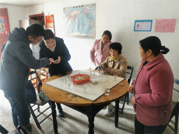 图三 驻村工作队走访村民.jpg