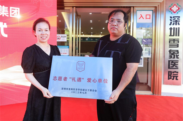 图片2，吉华街道义工联理事长吴军勇（右）为深圳雪象医院院长汤俊英授志愿者“礼遇”爱心单位牌匾.jpg