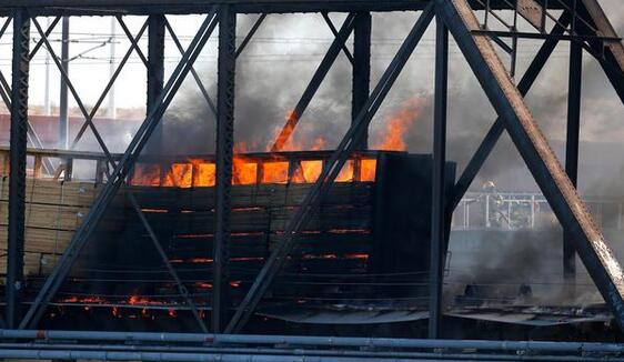 美一火车脱轨引大火 桥樑垮塌