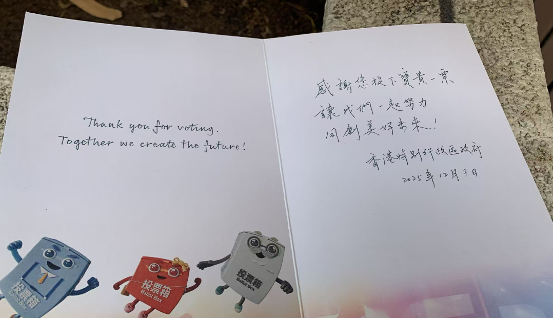 選民持心意卡在票站外拍照留念 冀選出議員為民服務