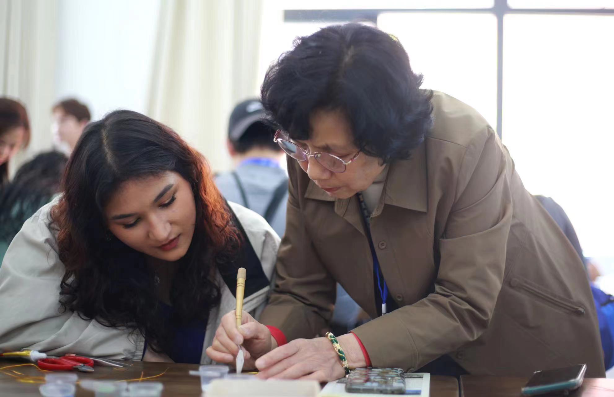 图一  祝慧兰大师在教外籍学生点蓝（体验景泰蓝工艺）.jpg