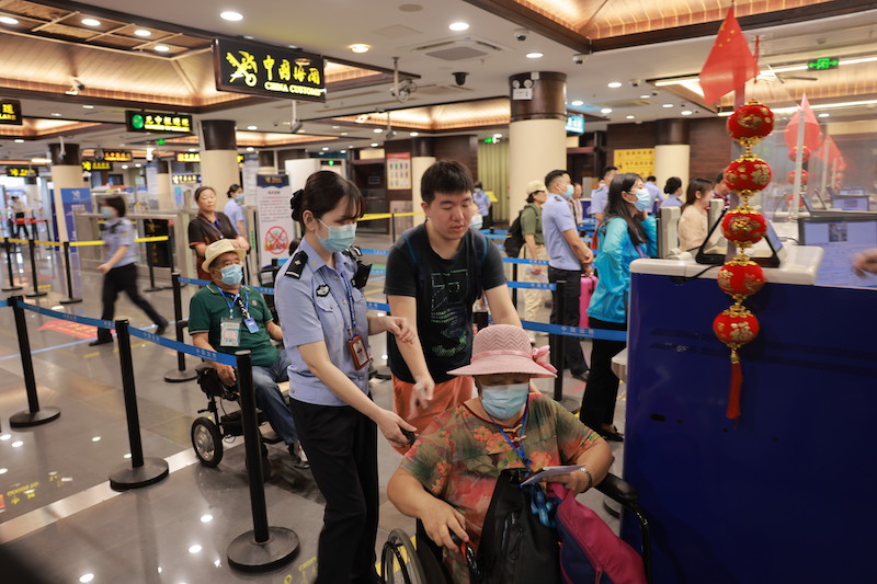 圖1 三亞邊檢站移民管理警察正在協助老年旅客通關.jpg