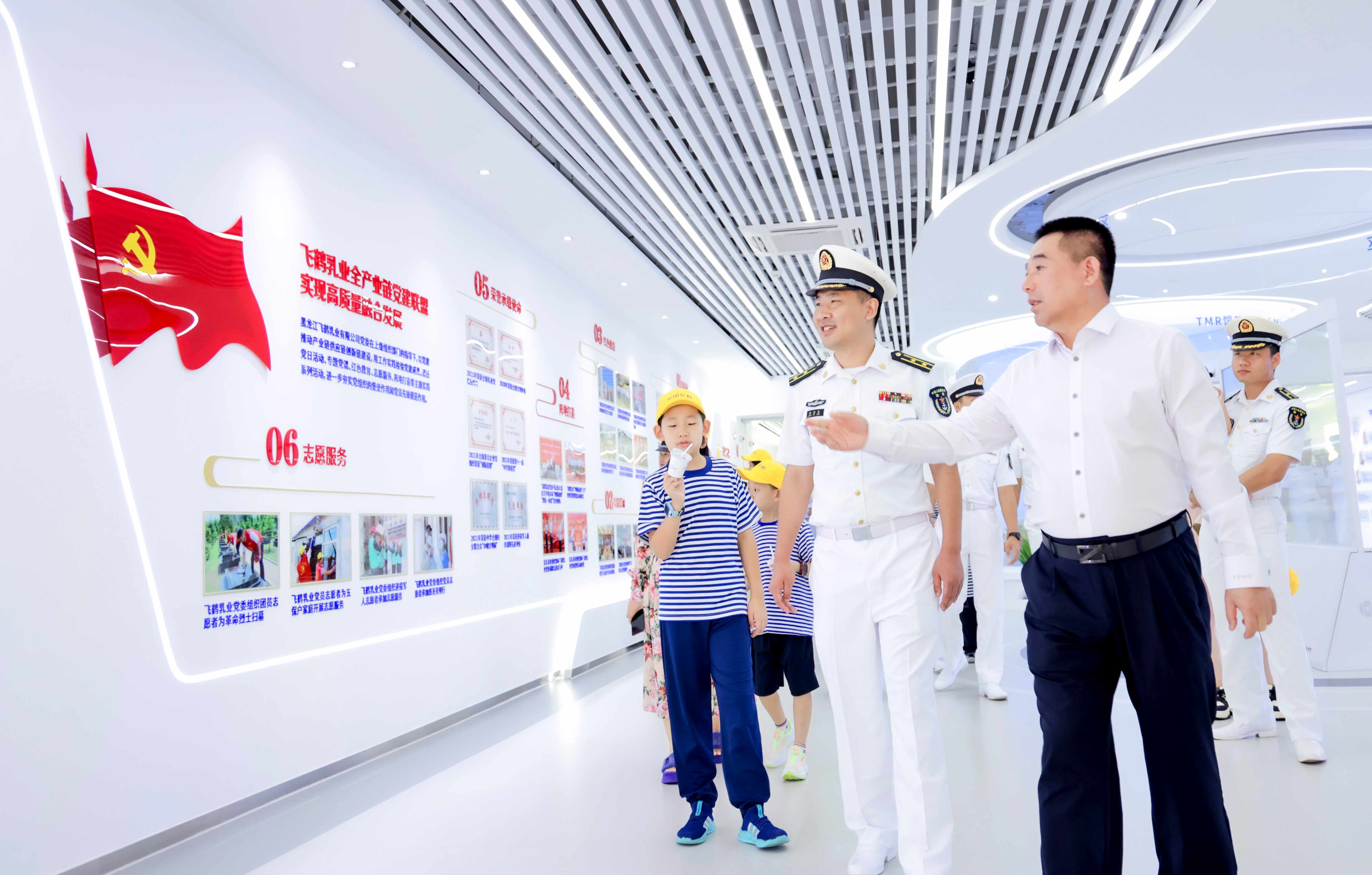 2-飞鹤乳业集团党委书记朱天龙(右)向舰上官兵介绍飞鹤乳业党建.jpg