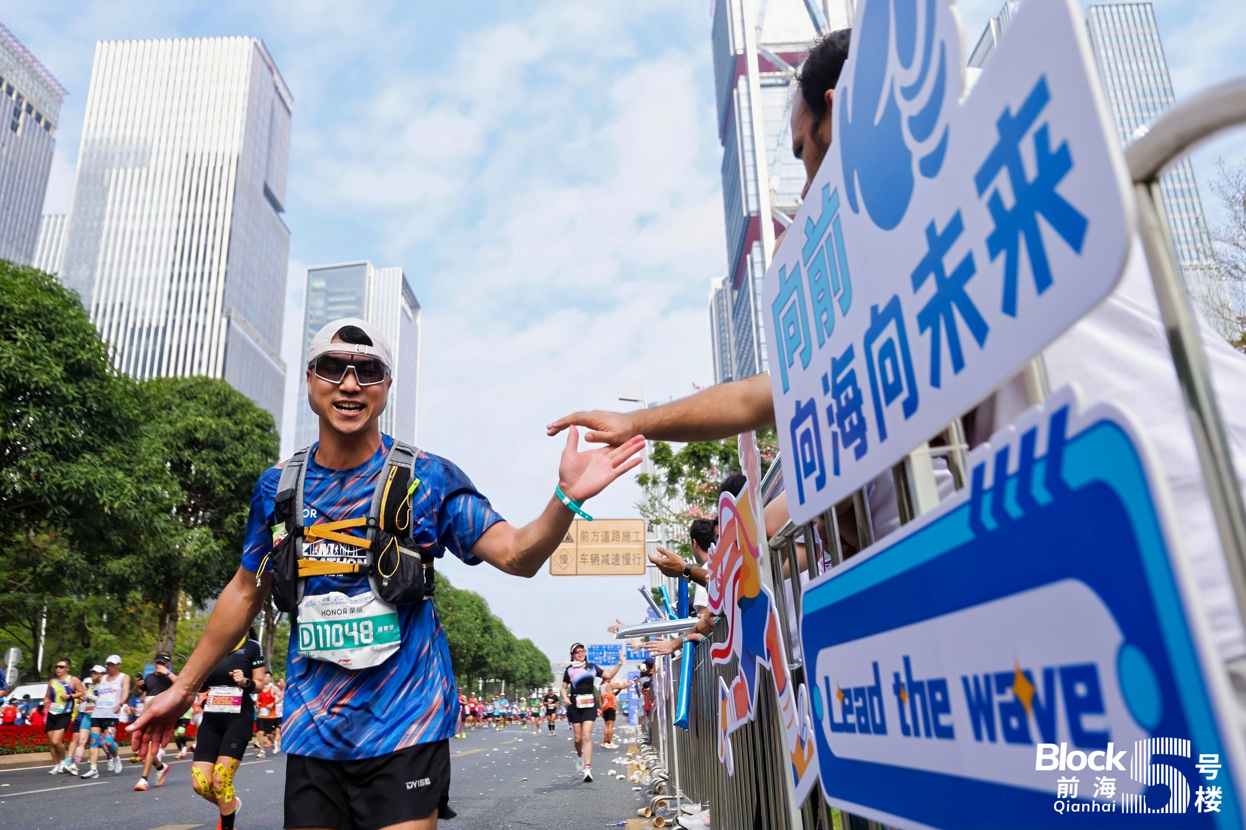 1-参赛跑者途径前海五号楼,和志愿者拍手庆祝。.jpg